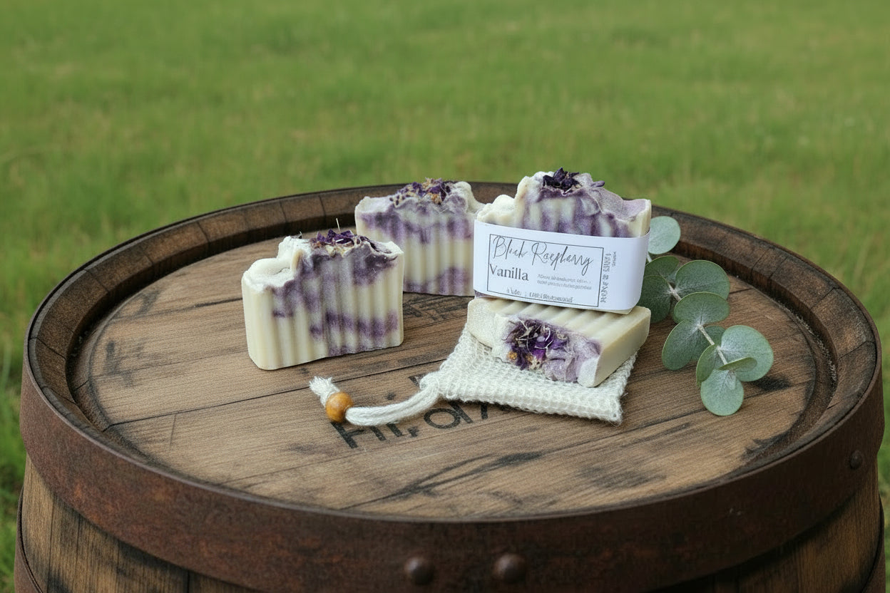 Two soaps with a decorative bag on a wooden board with 'Timber & Tallow Soaps' branding.