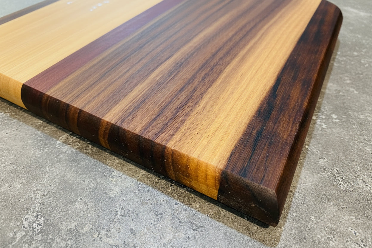 Wooden cutting board with a multicolored grain pattern on a concrete surface