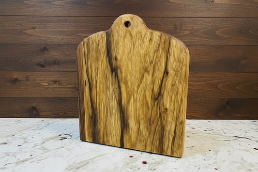 Wooden cutting board on a marble surface with a wooden wall background