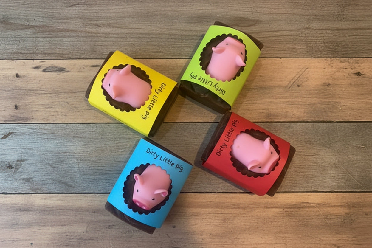 Four small boxes with pink pig-shaped objects on a textured surface