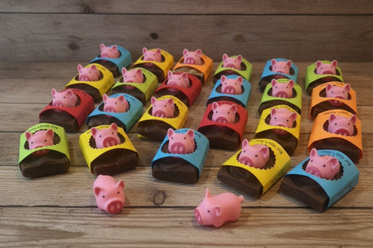 Colorful chocolate bars with pig designs on a gray surface