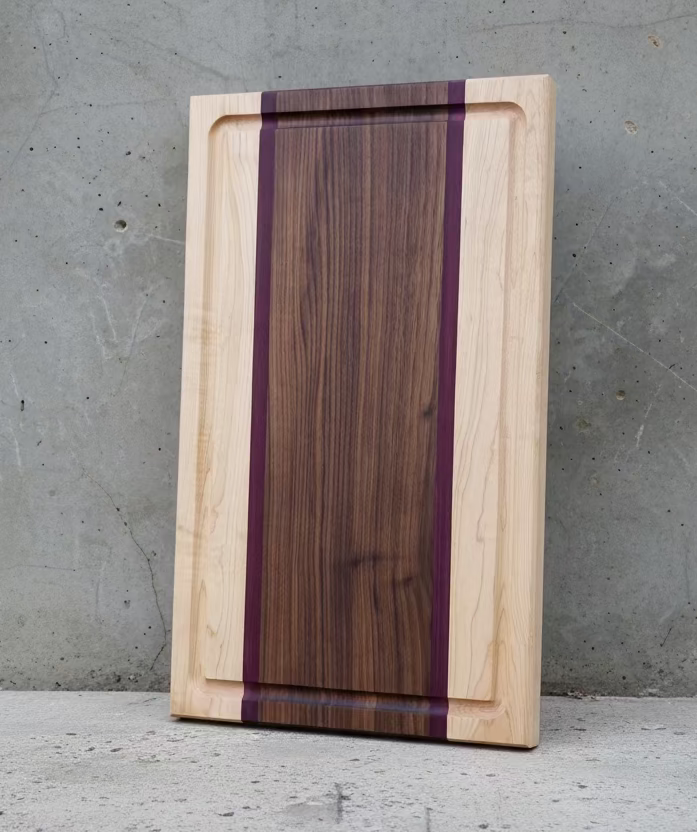 Maple, Purple Heart and Walnut Cutting Board with a concrete backsplash