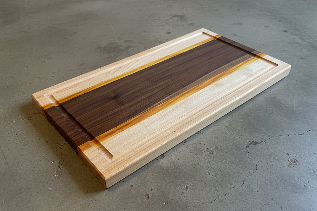 Maple Yellow Heart and Walnut cutting board on a concrete surface