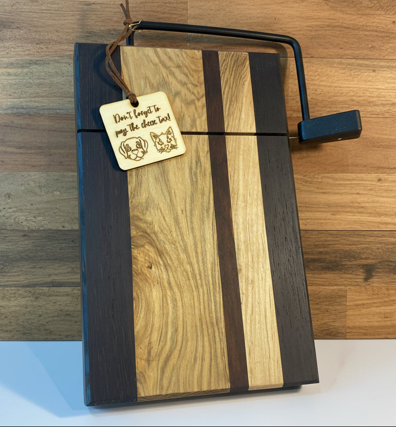 Wooden cutting board with a black border and engraved tag on a wooden surface