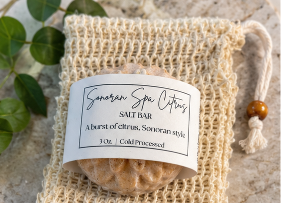 Salt bar in a mesh bag with a label on a textured surface with greenery.