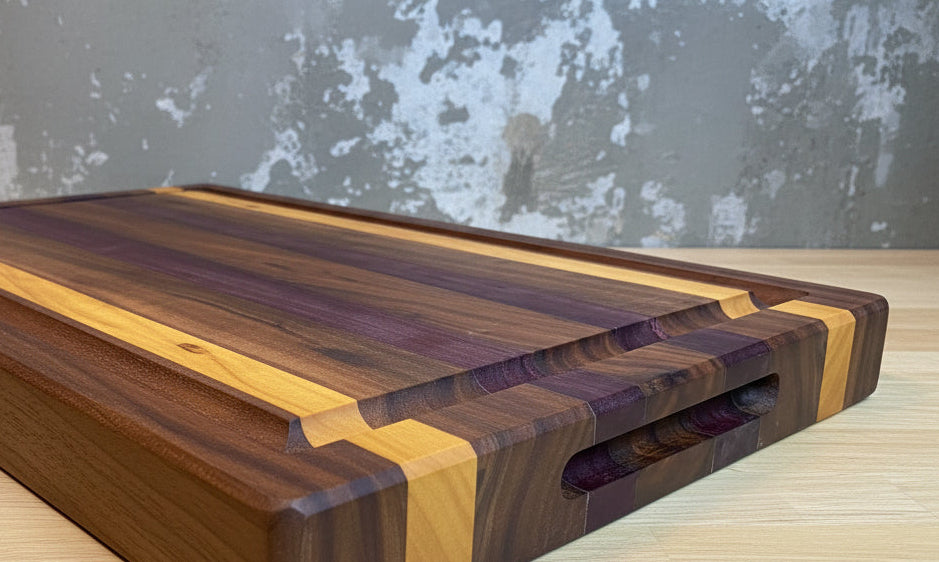 Wooden cutting board with a wavy grain pattern on a wooden surface.