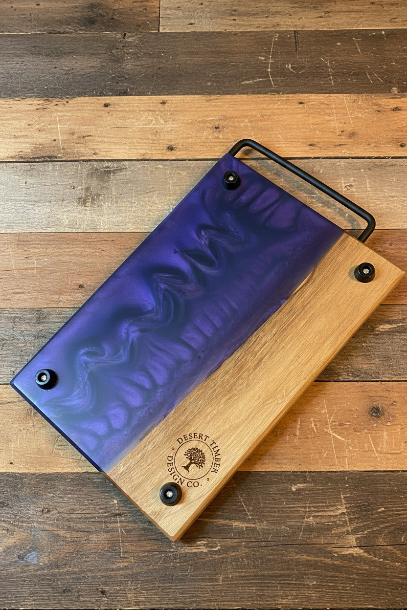 Wooden cutting board with purple resin top on a wooden surface