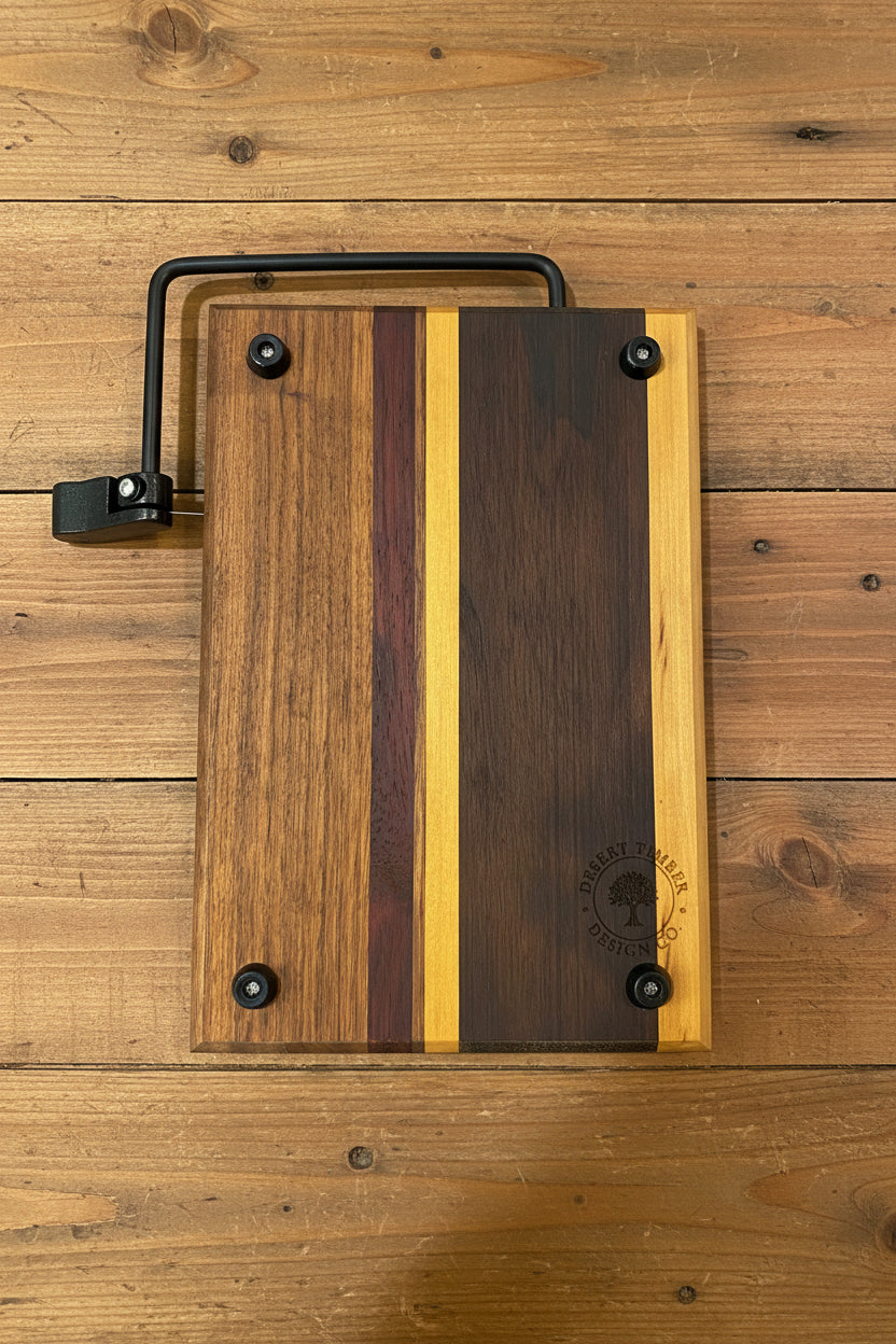 Wooden cutting board with a black handle on a wooden surface